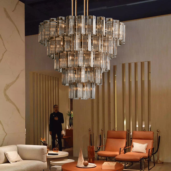 Luxurious living room with a large chandelier, orange chairs, and a beige sofa.